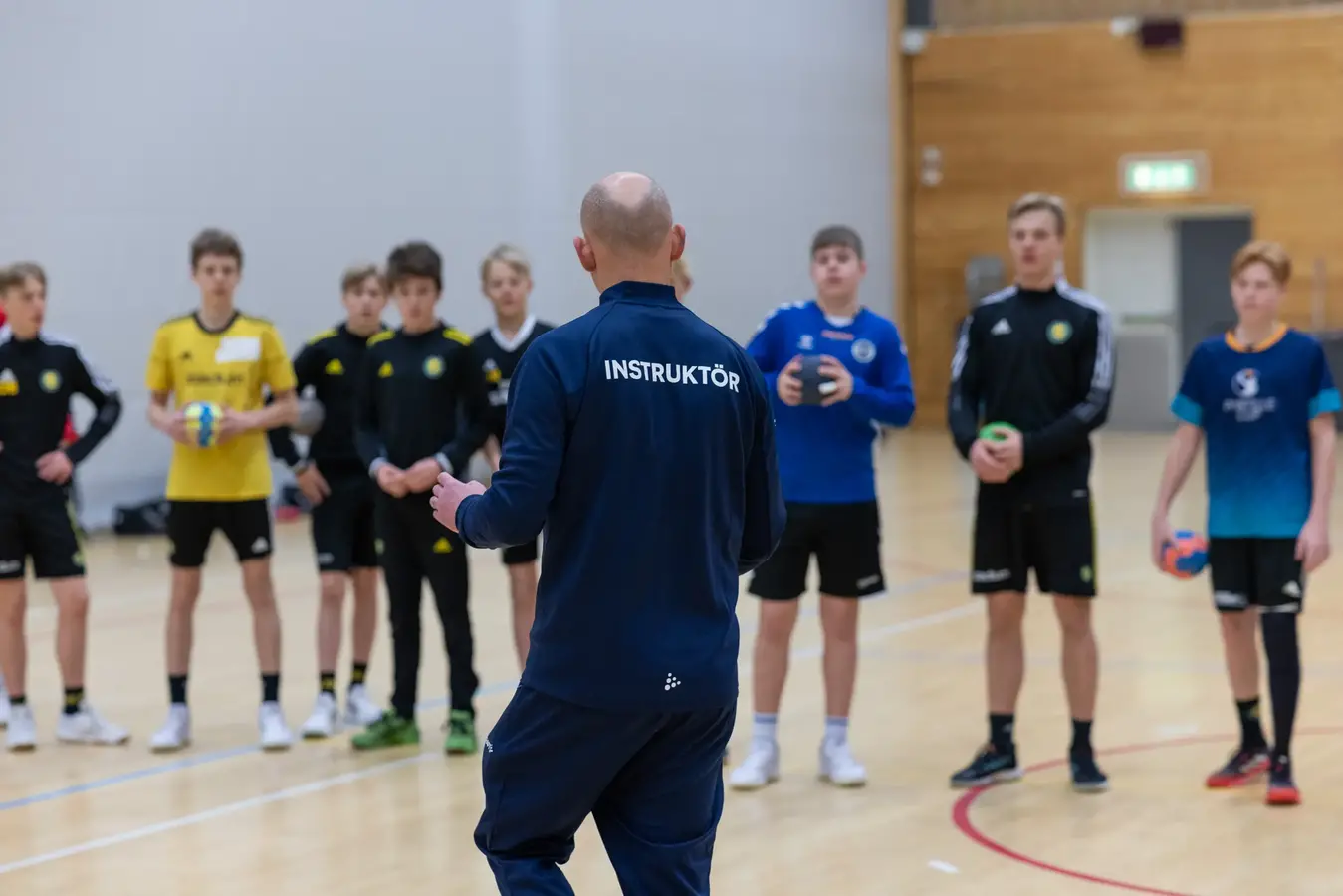 instruktör pratar med spelare som står mot honom